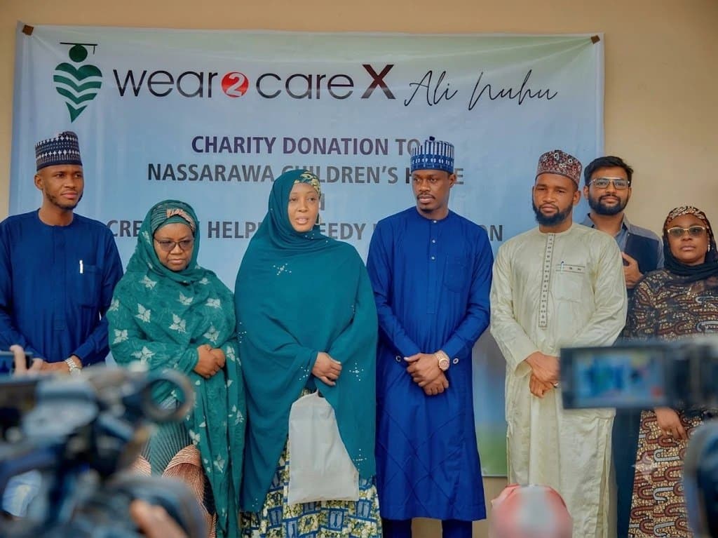 Representatives gathered for the Wear2Care x Ali Nuhu charity donation, beneath the campaign banner