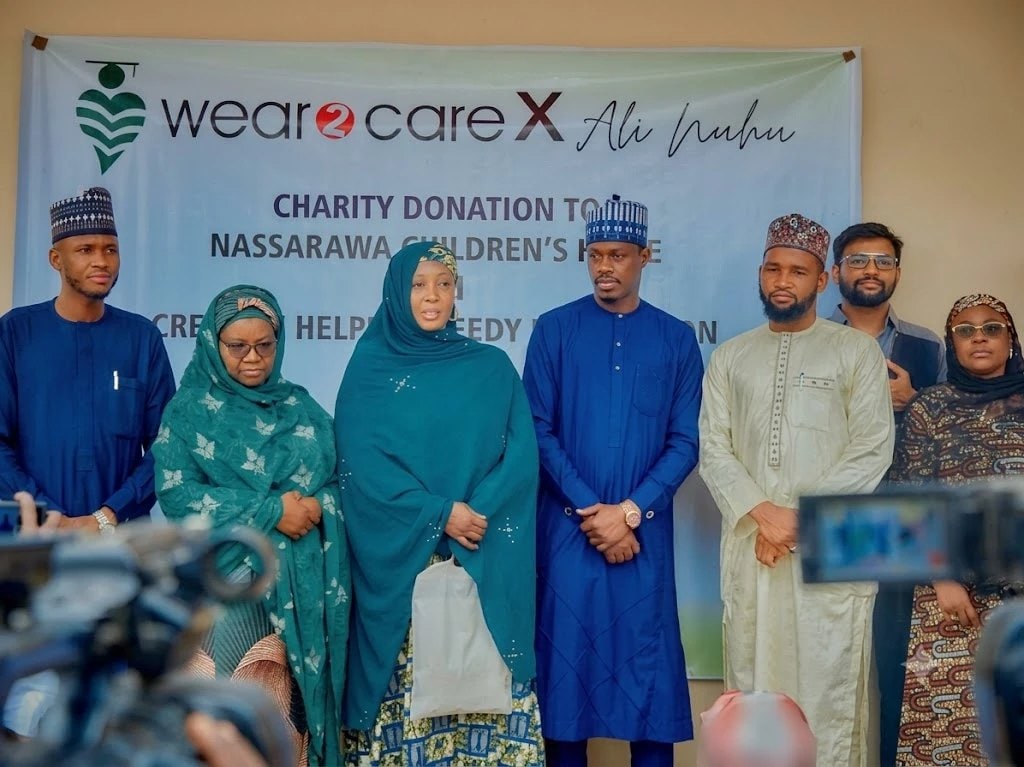Representatives gathered for the Wear2Care x Ali Nuhu charity donation, beneath the campaign banner